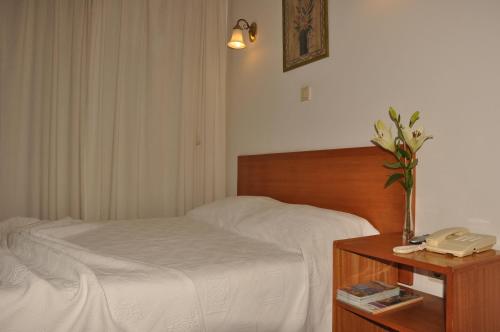 a bedroom with a bed and a phone on a table at Residencial D. João III in Ponta Delgada