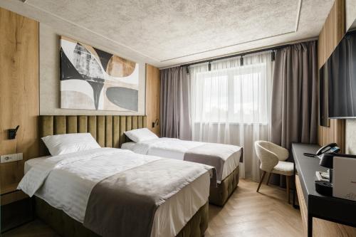 a hotel room with two beds and a desk at Campeador Expo in Bucharest