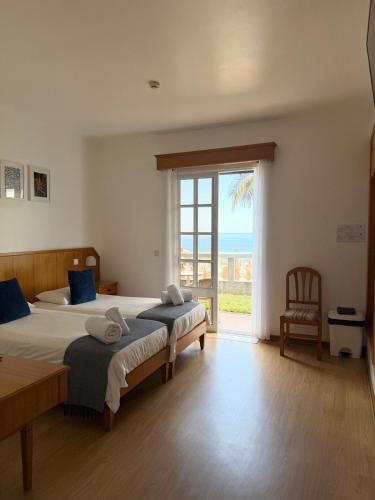 a bedroom with two beds and a large window at Valhalla Panorama in Funchal