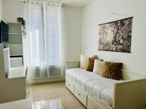 a white room with a couch with a window at Chic & Cosy in Antibes