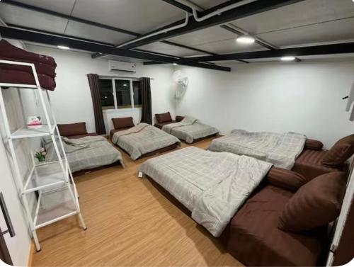 a living room with three beds and a couch at Phuket Hostel at Town in Phuket