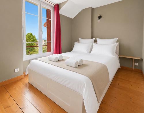a bedroom with a large white bed with towels on it at T3 lumineux, central, parking & confort moderne in Saint-Cyr-lʼÉcole