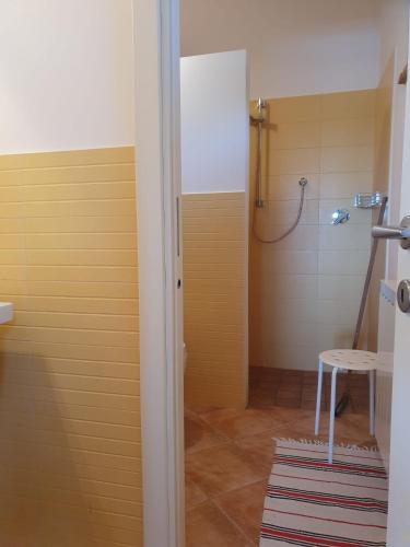 a bathroom with a shower with a table and a stool at La Cassetta Rossa in Corinaldo