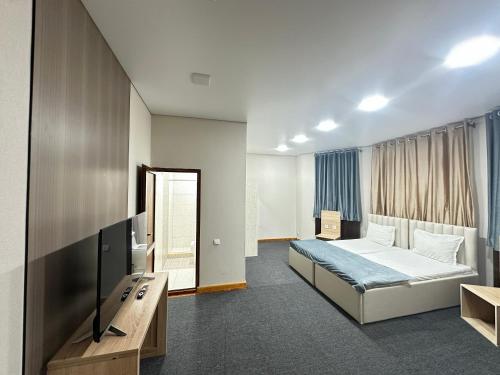 a hotel room with a bed and a television at Center Hotel Darhan in Tashkent