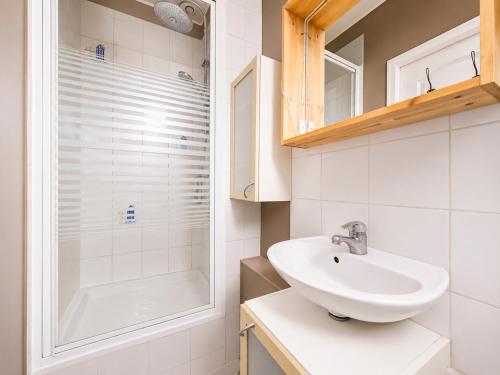 a white bathroom with a sink and a shower at T3 lumineux, central, parking & confort moderne in Saint-Cyr-lʼÉcole