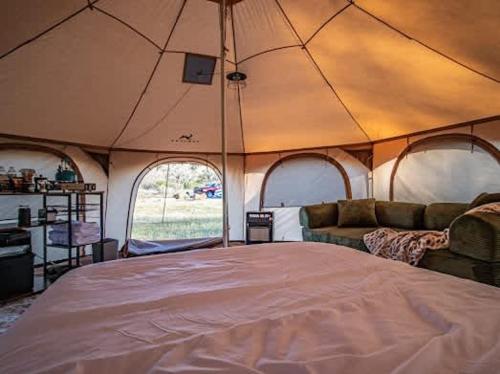 a large tent with a bed and a couch at Mesa Verde Tent in Farmington