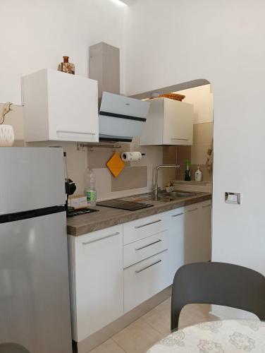 a kitchen with white cabinets and a refrigerator at Oasi nel cuore di Noto in Noto