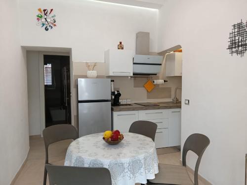 a kitchen with a table with a bowl of fruit on it at Oasi nel cuore di Noto in Noto