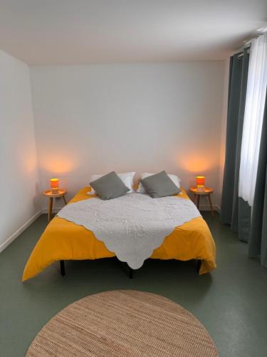 a bedroom with a large bed with two side tables at Studio Les écuries de la forêt in Le Buisson Genois