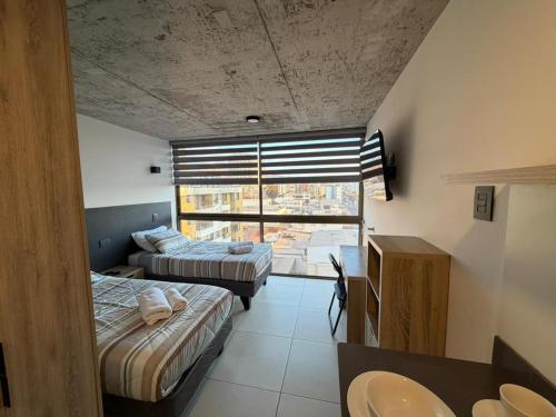a bedroom with two beds and a sink and a window at Hoteles JMC in Antofagasta