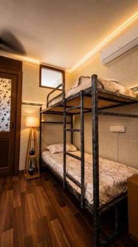 two bunk beds in a room with a lamp at Checkpoint backpacker in New Delhi