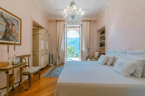 a bedroom with a large bed and a chandelier at Villa Castiglioni Luxury Apartment in Laglio