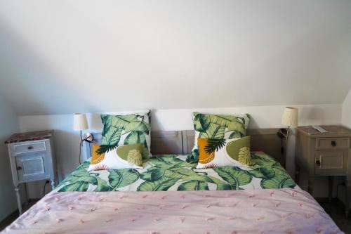 a bedroom with a bed with tropical pillows at L'Atelier des dépendances in Lipsheim