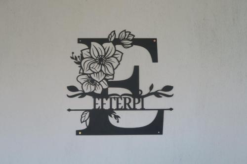 a letter f with flowers on a wall at Efterpi seaside house in Chrysi Ammoudia