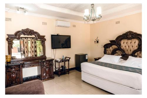 a bedroom with a large bed and a television at Leon's Lodge in Choma