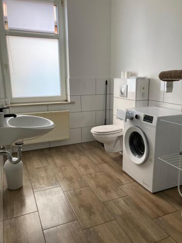 a bathroom with a washing machine and a toilet at Arnold Apartments in Glauchau
