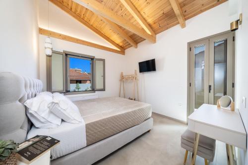 a bedroom with a bed and a desk at La Villa Du Soleil in Sami