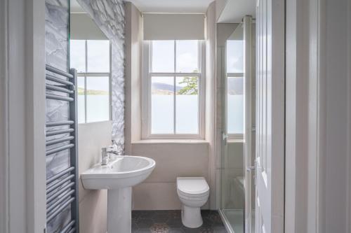 a bathroom with a sink and a toilet and a window at Cameron Fell Apartment Keswick at The Lairbeck in Keswick