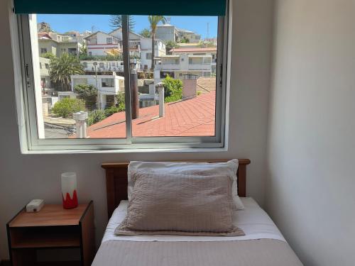 a bedroom with a bed and a large window at Hostal Recreo in Viña del Mar