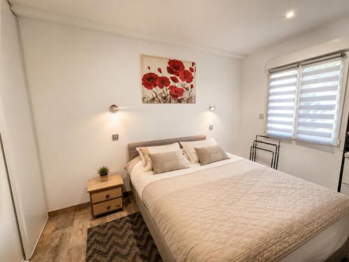 a bedroom with a large bed and a painting on the wall at Au lit de Vin in Saint-Sulpice-de-Faleyrens