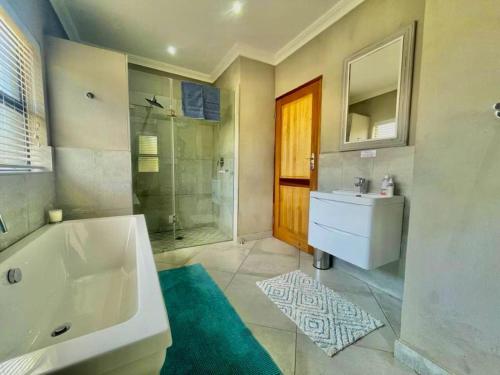 a bathroom with a tub and a sink and a shower at Greens & Dreams in Parys