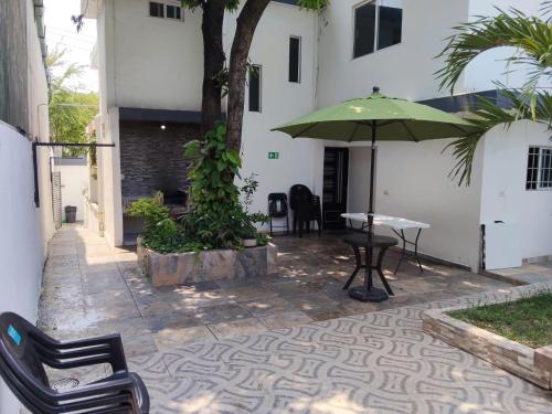 a patio with a table and a green umbrella at Casa Bell in Ciudad Valles
