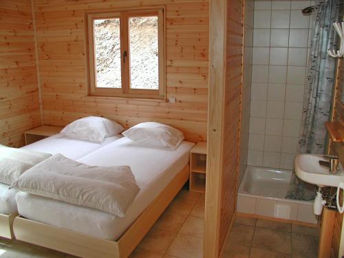 ラ・ロシュ・アン・アルデンヌにあるLes Rochettes - Jupiterのベッドルーム(ベッド1台、バスタブ付)