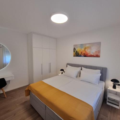a bedroom with a large white bed with white walls at Apartman Zalar in Lopar