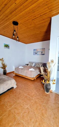a bedroom with a bed and a wooden ceiling at Pefkos Sea Shell in Pefki