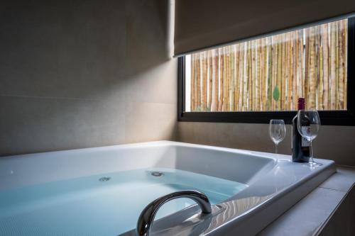 a bath tub with a sink and a window at Botanique Veadeiros in Alto Paraíso de Goiás