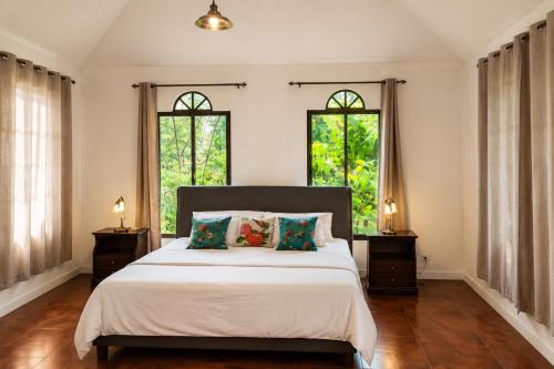 a bedroom with a large bed with two windows at Villa Sulterra in Tambor