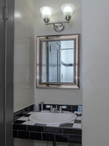 a bathroom with a sink and a mirror at Gardner Hotel & Hostel in El Paso