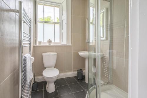 a bathroom with a toilet and a sink and a shower at Bethby Beck Apartment Keswick at The Lairbeck in Keswick