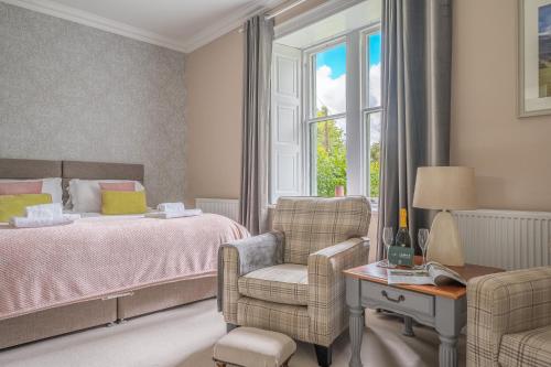 a bedroom with a bed and a chair and a window at Bethby Beck Apartment Keswick at The Lairbeck in Keswick