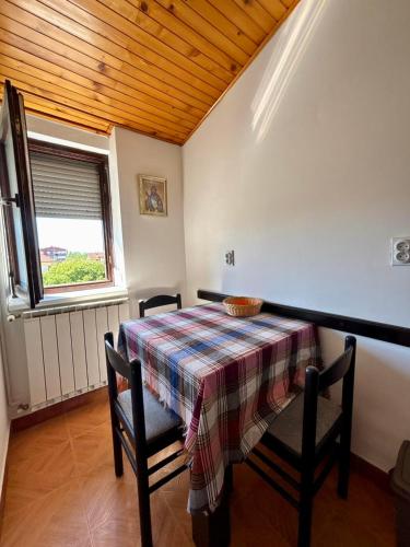 a dining room with a table and chairs and a window at Apartman Stankovic in Pirot