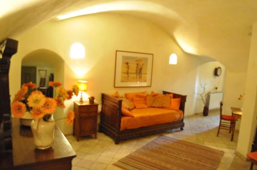 una sala de estar con sofá y un jarrón de flores en Onofrio Flat, en Roma