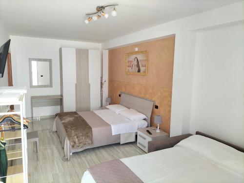 a hotel room with two beds and a television at Casa Vacanze " ORTE " in Otranto