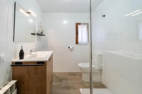 a white bathroom with a sink and a toilet at CASA LA FELICIDAD in Beceite