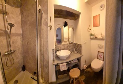 a bathroom with a sink and a shower and a toilet at A La Maison in Les Repôts