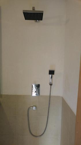 a shower in a bathroom with a shower head at Quiet Garden in Rishon LeẔiyyon