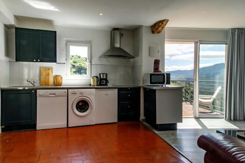 a kitchen with a washing machine and a microwave at Pyrénées Mon Amour in Felluns