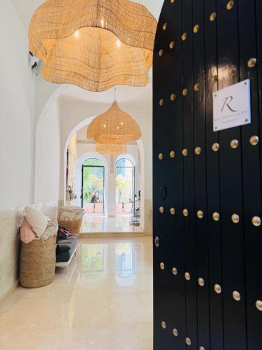 ein Raum mit einer schwarzen Tür mit einem Kronleuchter in der Unterkunft Riad Rafaele & SPA in Marrakesch