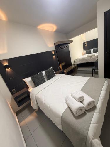ein Schlafzimmer mit einem großen weißen Bett, auf dem Handtücher liegen in der Unterkunft Hotel HS Confort in Orizaba