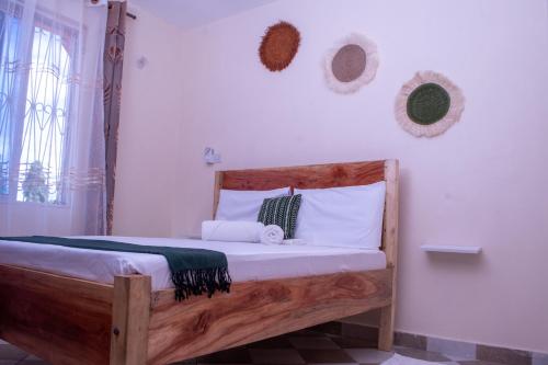 a bedroom with a wooden bed with white pillows at Meyer Stays in Kilifi