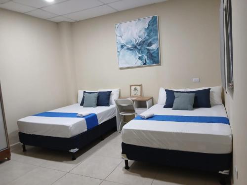 a room with two beds and a table in it at Nómada San Miguel in Colonia Milagro de La Paz