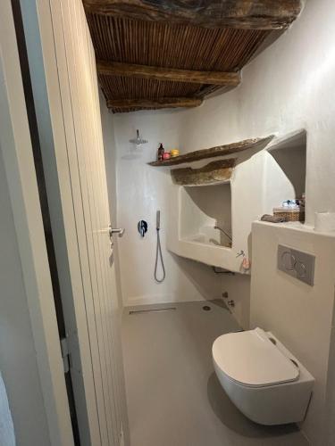 a bathroom with a white toilet and a wooden ceiling at Marpissa - Traditional House in Márpissa