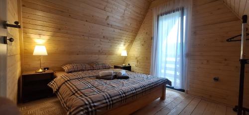 a bedroom with a bed with wooden walls and a window at Apartment & Cottage - Tune in Ripci