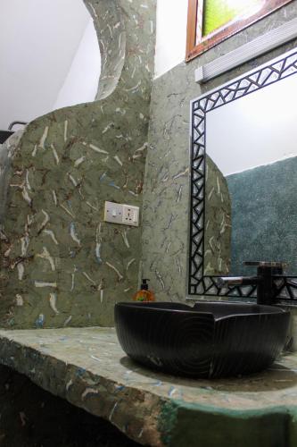 a bathroom with a sink in a stone wall at Sagando Bungalow in Michamvi