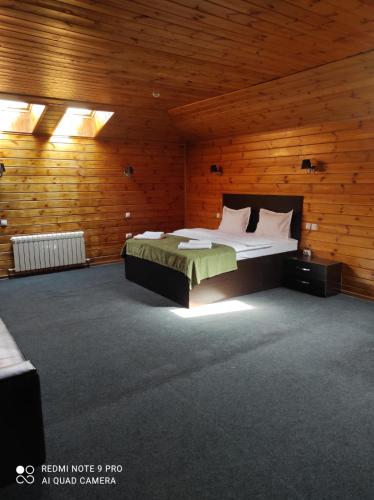 a bedroom with a bed in a wooden room at Pride Hotel in Taraz
