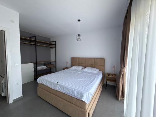 a bedroom with a large bed with white sheets at Vila Mirko in Kotor